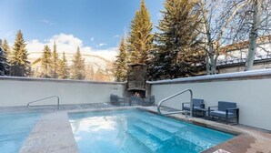 A swimming pool with a stone edge, a fire pit, and outdoor seating. - Condo with Outdoor Heated Pool and Free WiFi by RedAwning (Vail)
