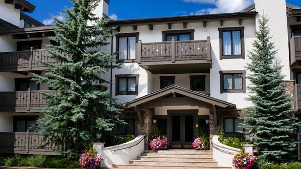 A multi-story building with balconies, a central entrance, and surrounding greenery. - Condo with Outdoor Heated Pool and Free WiFi by RedAwning (Vail)