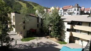 Zona residencial con una mezcla de edificios modernos y tradicionales, un patio central y una colina en el fondo.