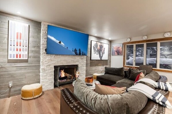 Cozy living room with a fireplace, flat-screen TV, and comfortable seating area.