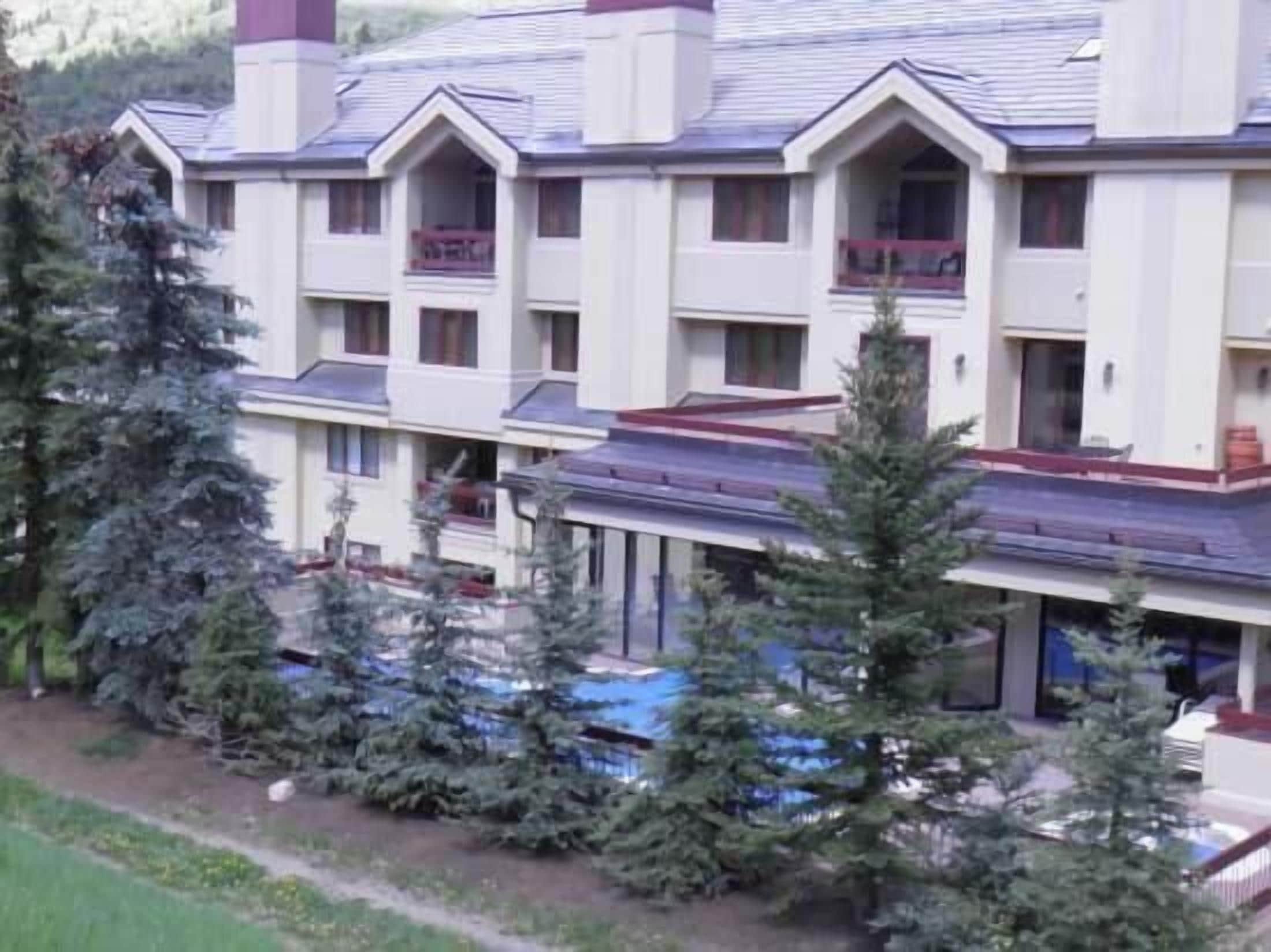 A multi-story hotel with a symmetrical facade, balconies, and a covered outdoor area.