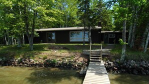 A wooden dock leading to a house surrounded by trees. - Ranch-Style Seidls Home Feet away to Lakeshore by RedAwning (Cable)