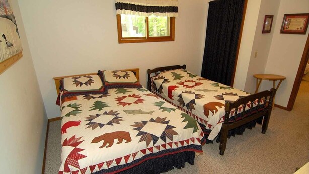 A room with two single beds, a window with a curtain, a small table, and a chair. - Ranch-Style Seidls Home Feet away to Lakeshore by RedAwning (Cable)