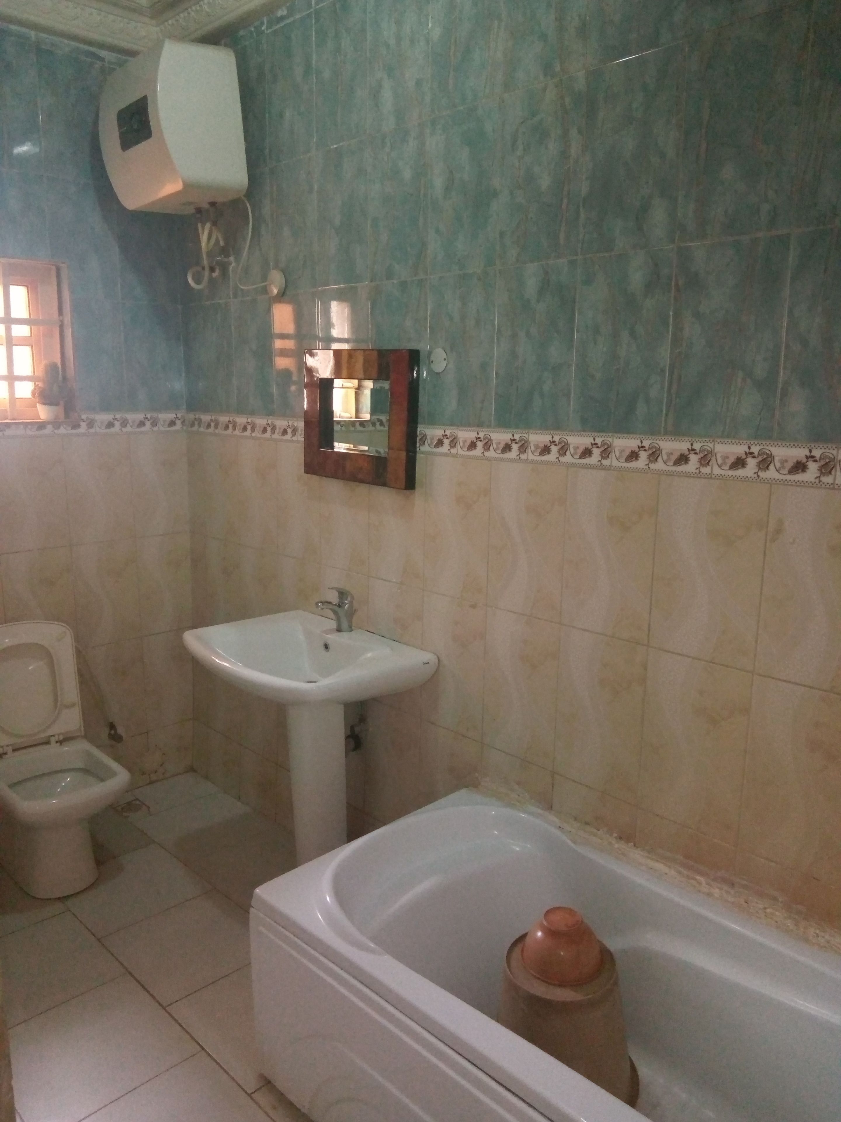 A bathroom with a toilet, sink, and bathtub.