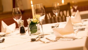 A table set for dining with clear glassware, folded napkins, and a candle. - The Dorset Golf Hotel (Wareham)