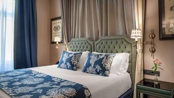 A neatly made bed with a floral bedspread, a headboard with a tufted design, and a bedside table with a lamp.