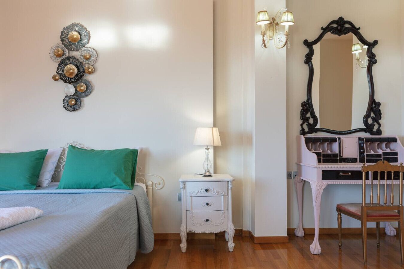 A bedroom with a bed, a nightstand, a dresser, a chair, and a mirror.