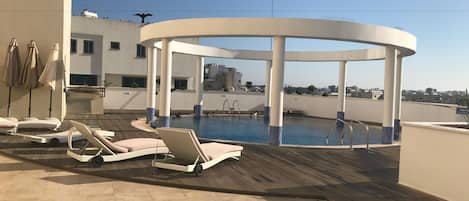 Piscine extérieure, parasols de plage, chaises longues