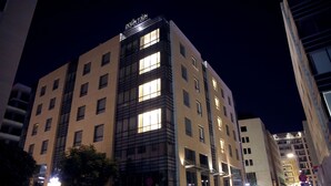Et hotel med flere etager, oplyste vinduer og et skilt med teksten "Downtown".