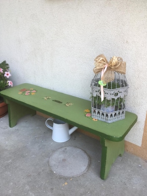 A green bench with floral designs and a metal birdcage with a ribbon. - L'aria di Casa (Alagna Valsesia)
