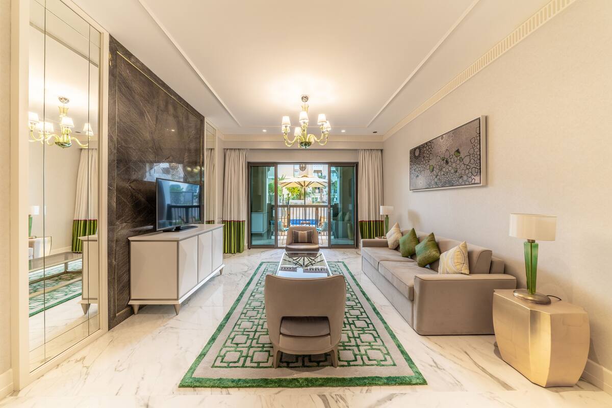 Un salon moderne comprenant un canapé, des fauteuils, une table basse et un téléviseur.