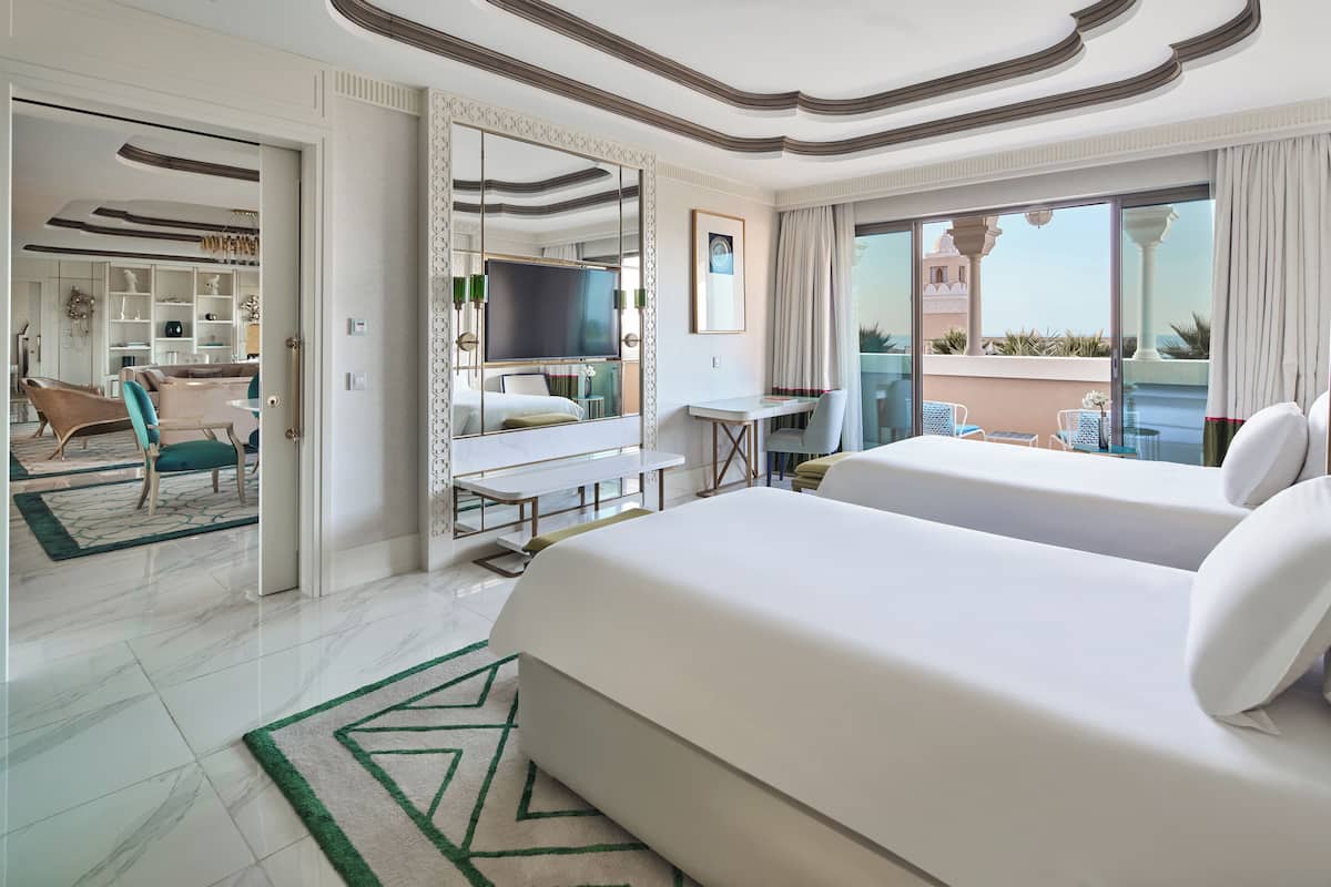 Une chambre d’hôtel avec un grand lit, un bureau, une télévision et un balcon avec vue.