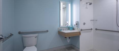 Un bagno con toilette, lavandino, specchio e doccia.