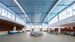 A spacious lobby with a high ceiling, large windows, and modern seating areas. - Universal's Endless Summer Resort - Surfside Inn and Suites (Orlando)