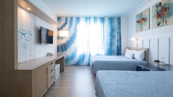 Une chambre d’hôtel moderne équipée de deux lits, d’une télévision, d’un bureau et d’une grande fenêtre avec des rideaux.