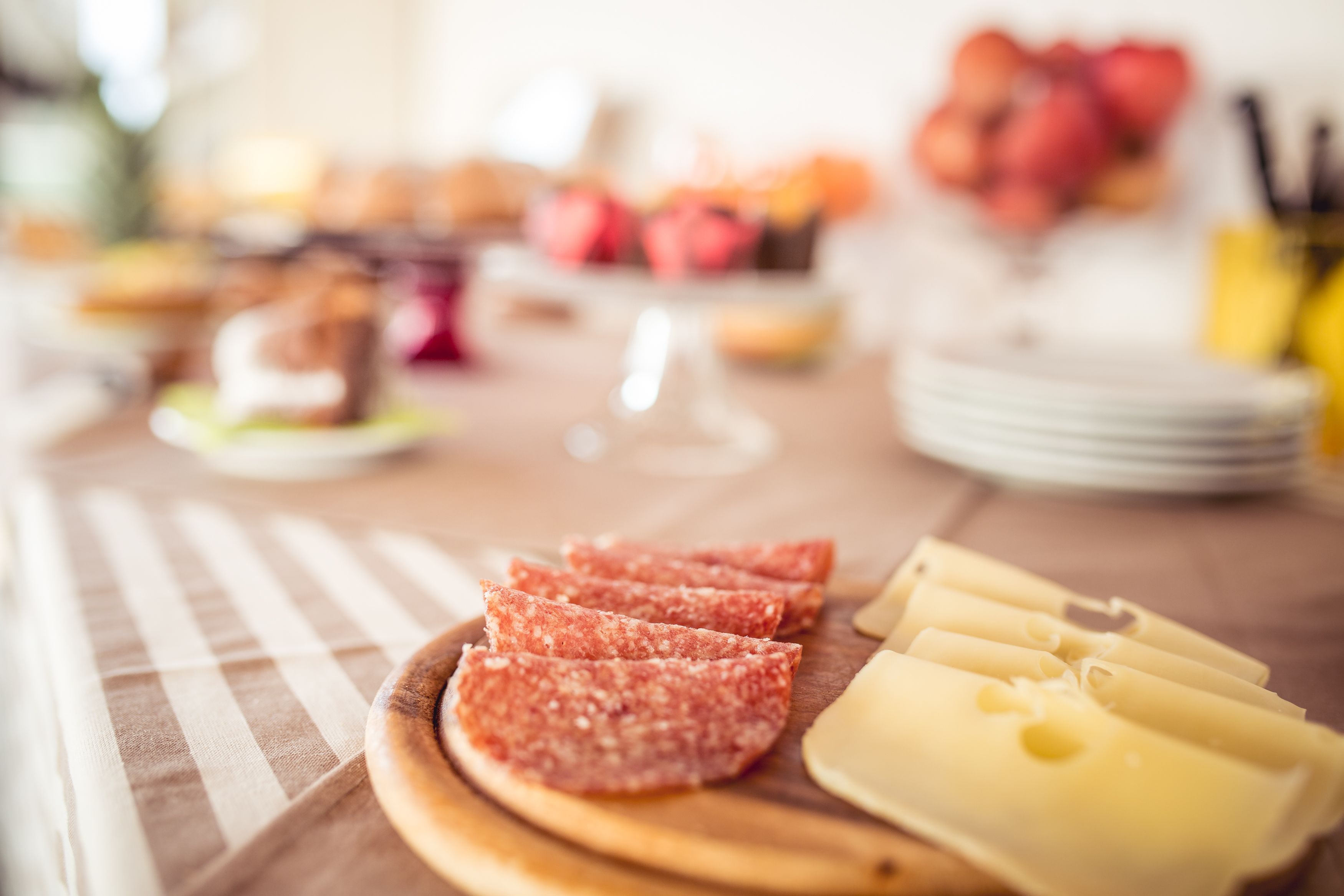 Une table garnie de divers aliments, notamment des viandes et des fromages coupés en tranches.