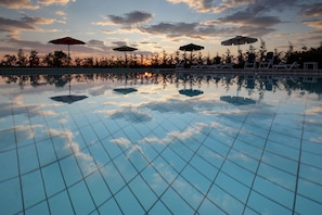 Alberca al aire libre y camastros