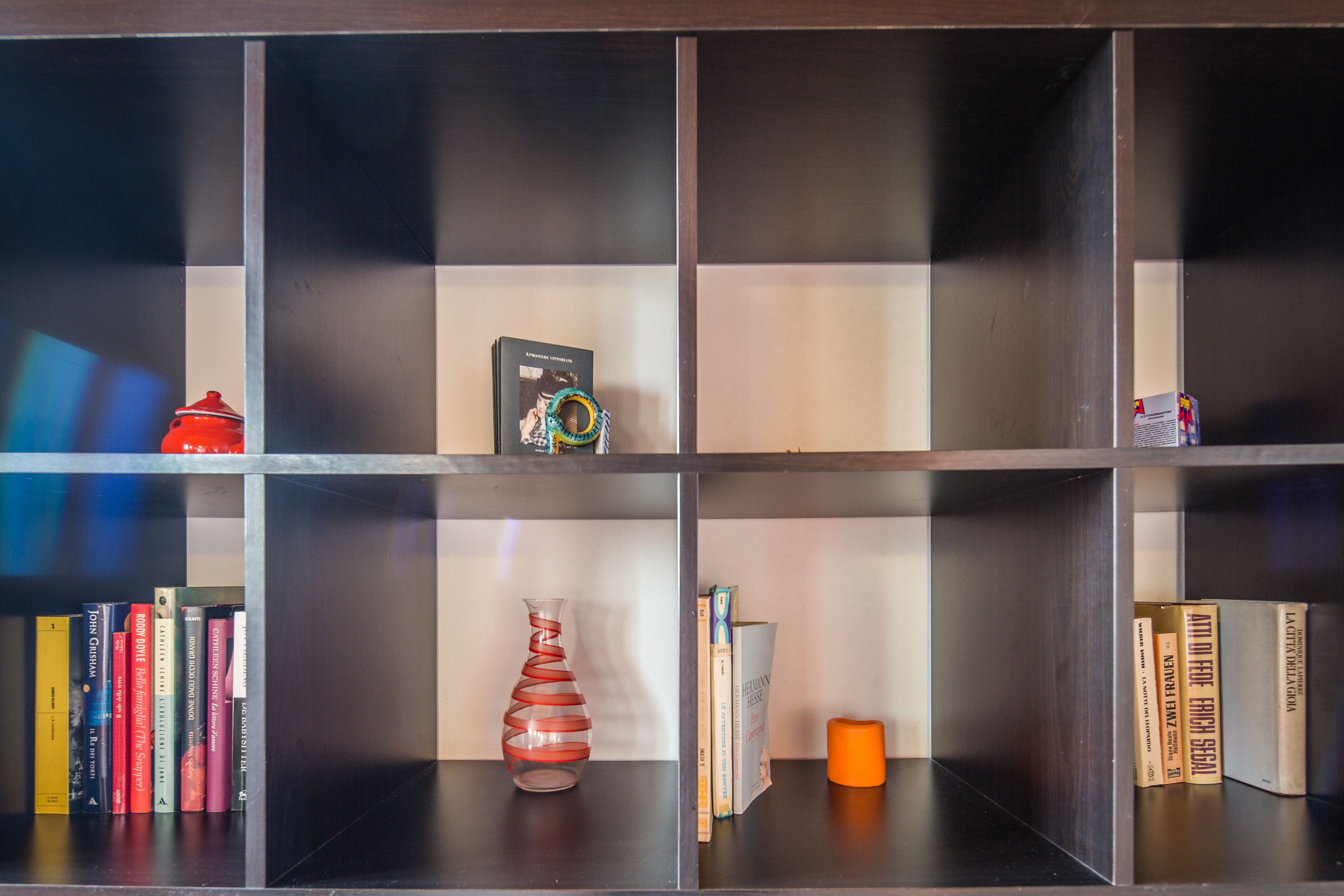 Une bibliothèque remplie de livres, un vase et des objets décoratifs.