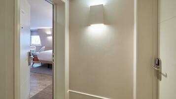 A hotel room with a bed, a desk, and a chair.