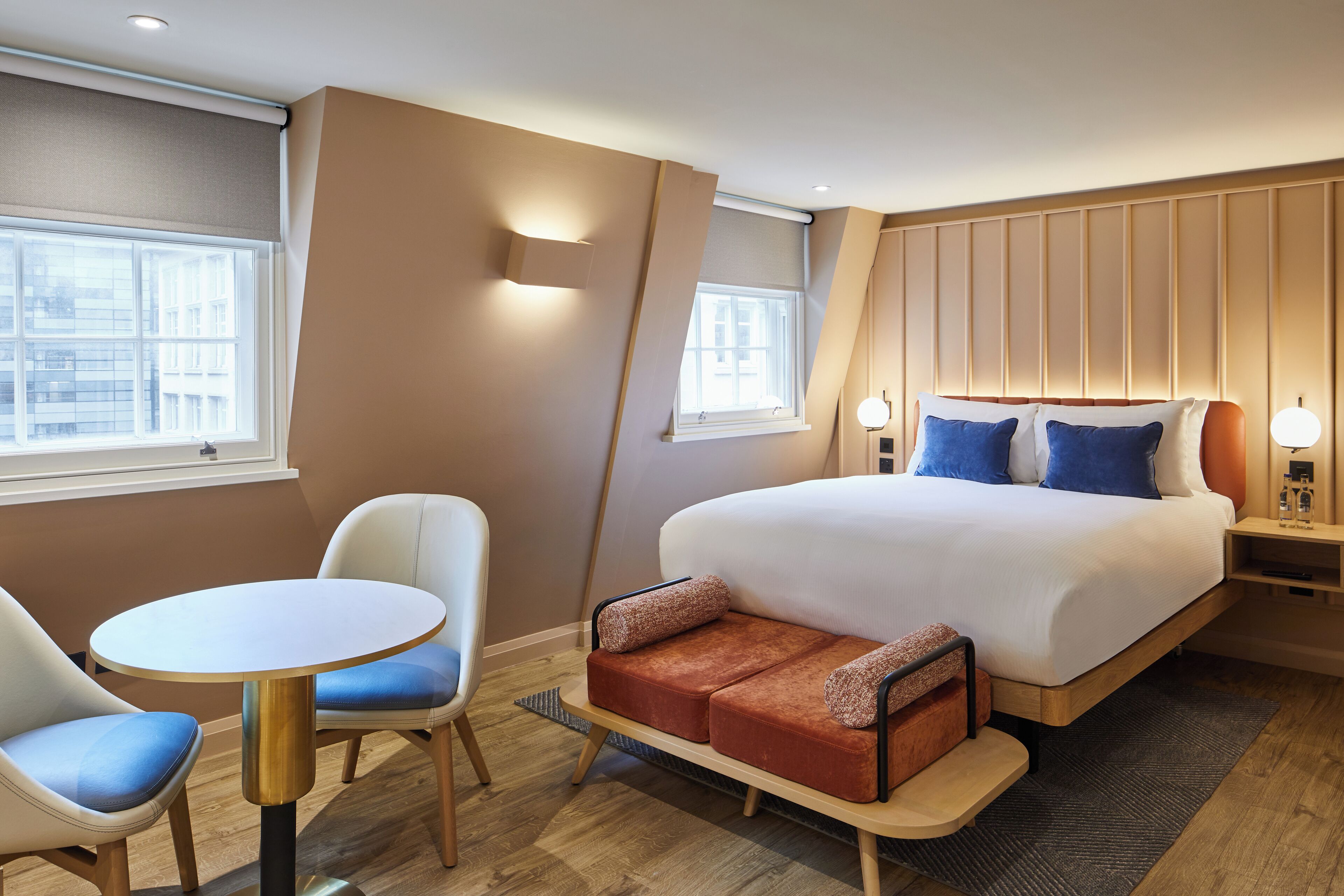 Une chambre d’hôtel avec un lit, un canapé, une table et des chaises.