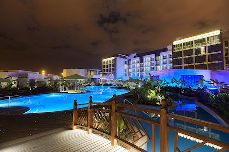 Indoor pool, outdoor pool, pool umbrellas, sun loungers. Millennium Resort Salalah