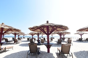 Relax in comfort under the shade of our beachside umbrellas, facing the ocean.