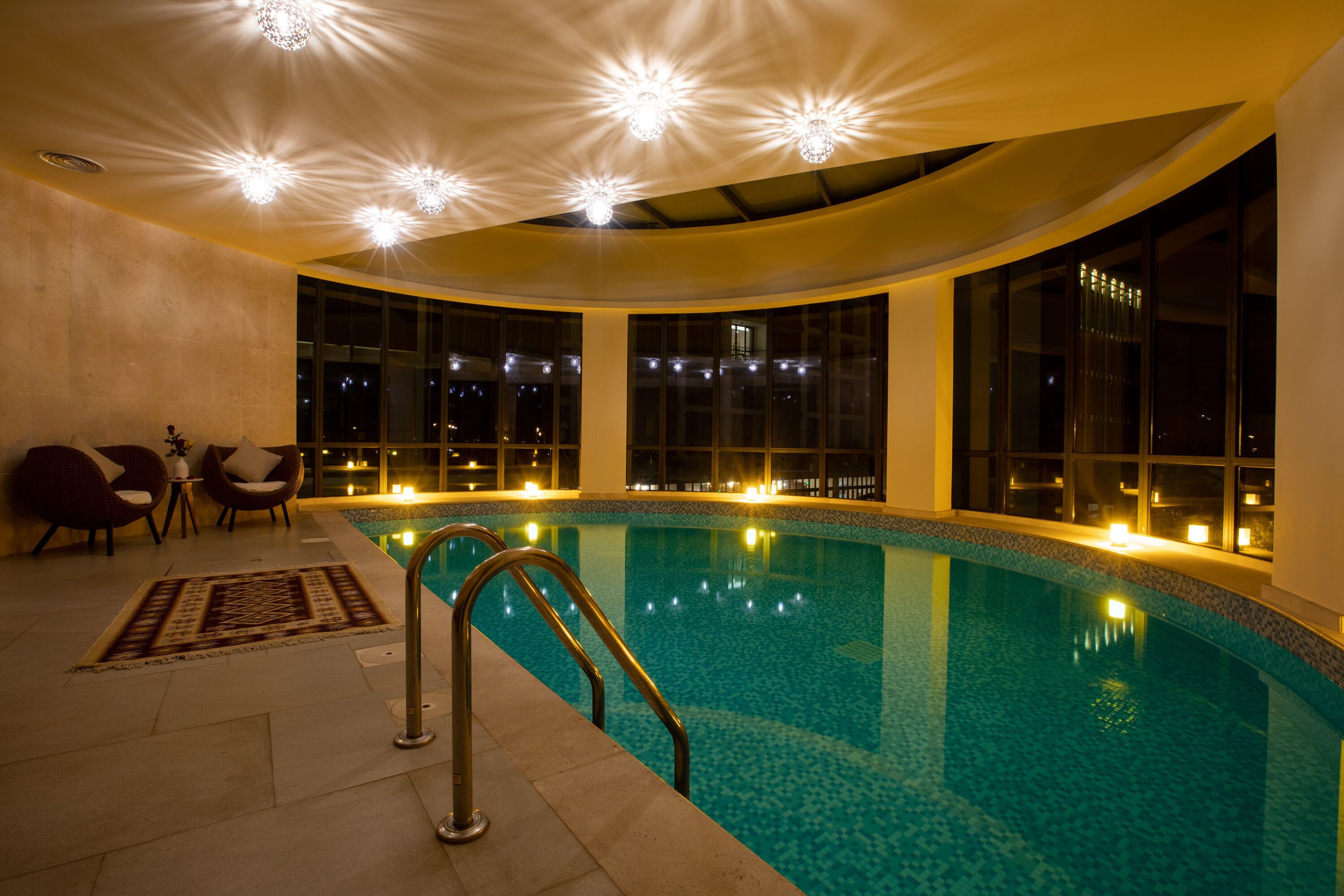 A swimming pool with a curved ceiling and large windows.