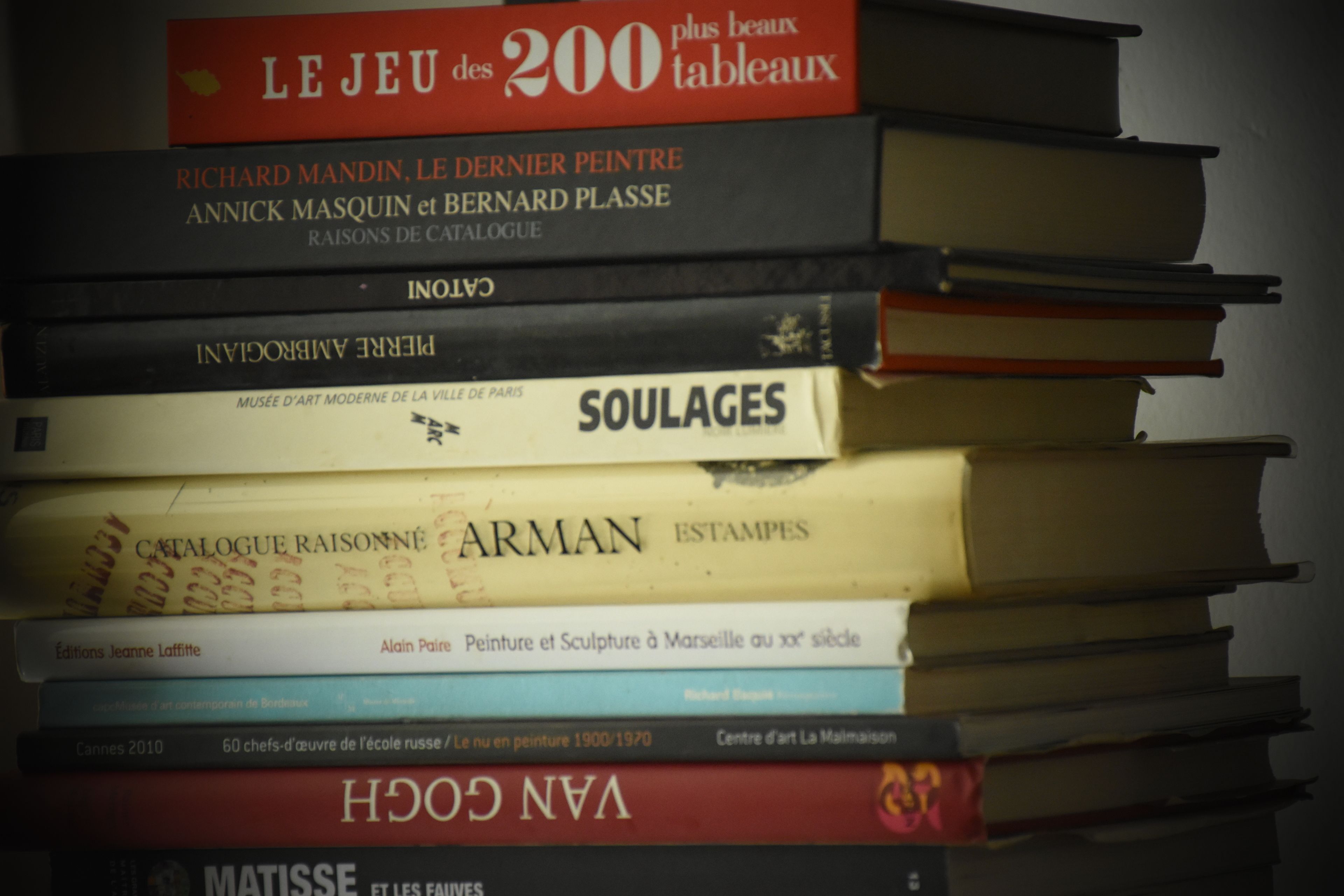 A stack of books with titles and authors visible.