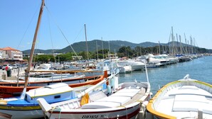 A marina with various boats docked, a clear sky, and a mountainous backdrop. - Val D'azur Chambres D'hôtes de Charme (Carqueiranne)