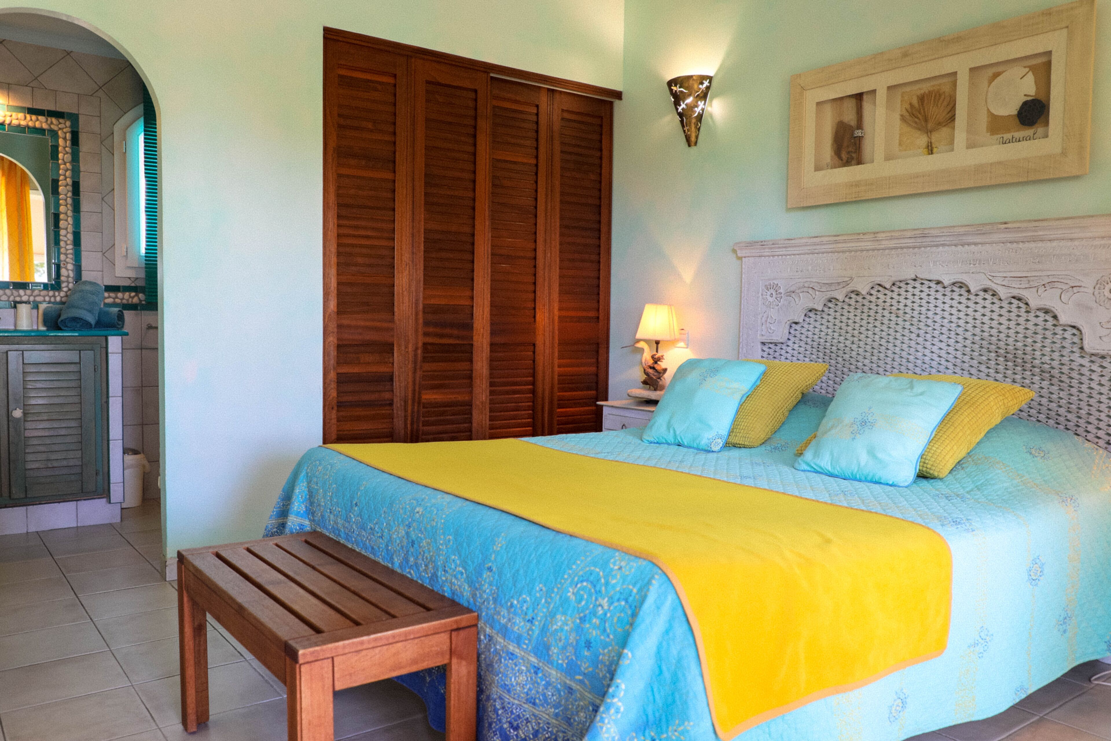 Un dormitorio con cama, armario de madera y una mesita.