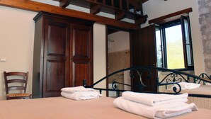Une chambre à coucher avec un lit, une armoire en bois et une fenêtre donnant sur un beau paysage.