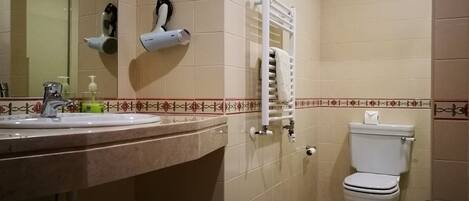 Een badkamer met een wastafel, spiegel, toilet en handdoekhouder.