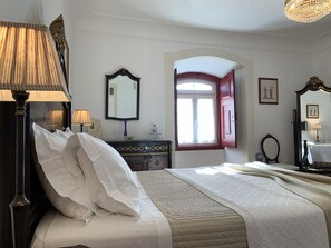 A neatly arranged bedroom with a bed, bedside tables, a dresser, and a mirror. - Casa do Peso (Crato)