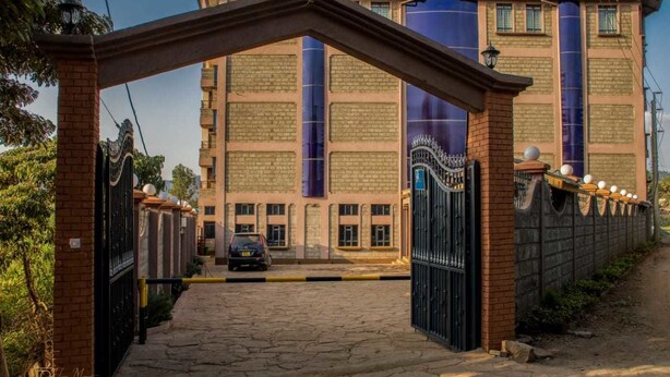 Una entrada porticada con un arco de ladrillo que da acceso a un edificio con grandes estructuras cilíndricas.
