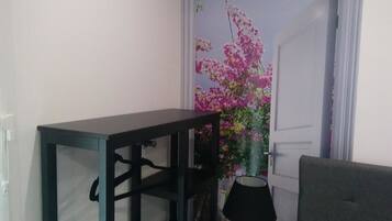 Une pièce avec une table en bois foncé, une lampe et une porte ornée de motifs floraux.
