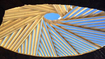 A spiral wooden structure with a clear blue sky in the background.