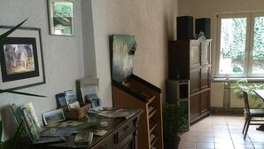 Una cocina con un armario de madera, un refrigerador pequeño y una planta en maceta.
