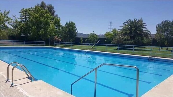 Una piscina al aire libre, tumbonas