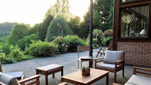 Un área de estar al aire libre con muebles de madera y una planta en maceta.