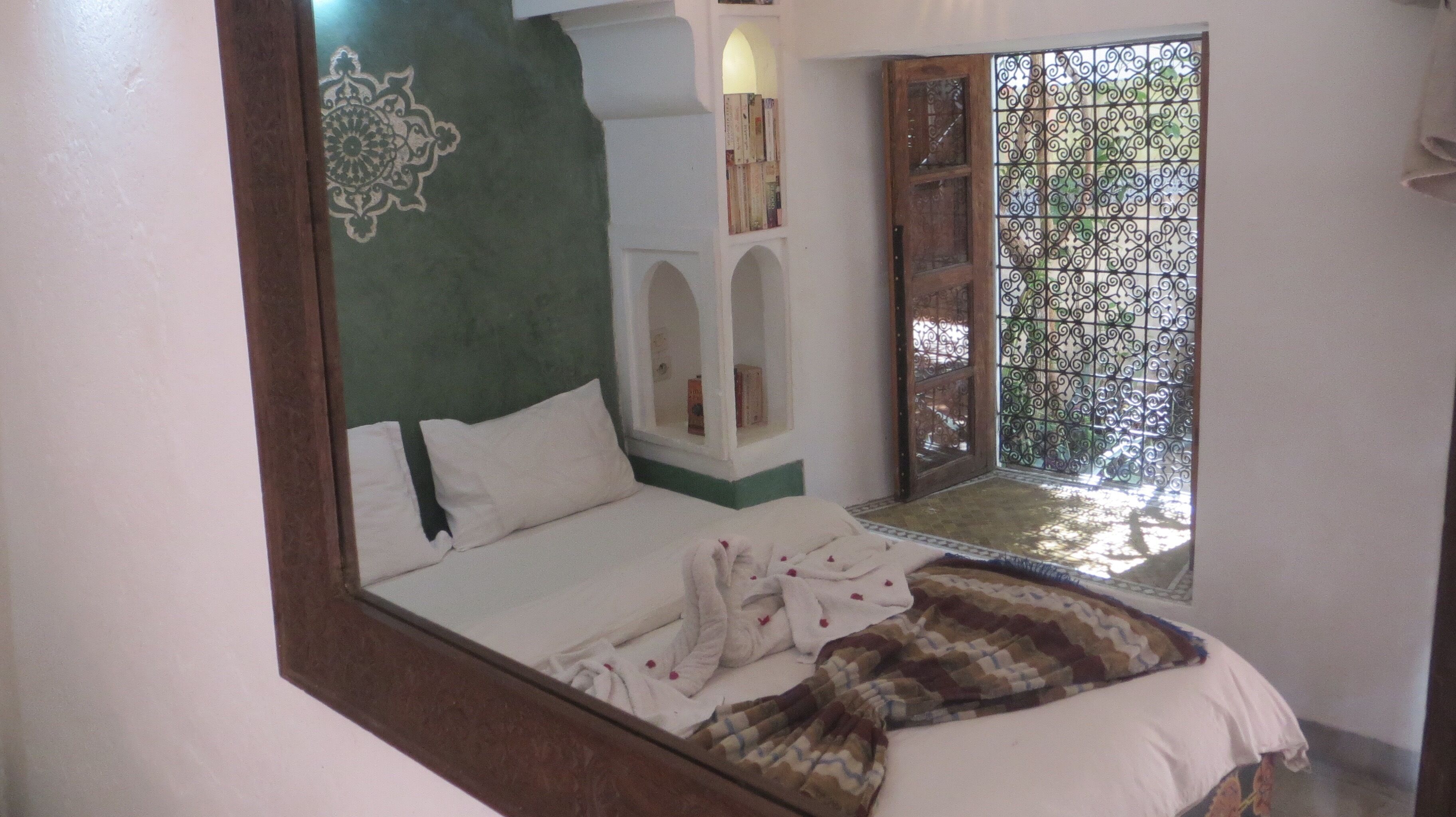 A bedroom with a bed, a window with a view, and a door leading outside.
