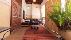 A cozy interior with a sofa set, a patterned rug, and a potted plant. - Riad Maizie (Marrakech)