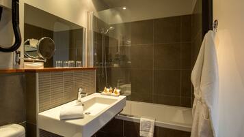 A modern bathroom with a white sink, a glass shower enclosure, and a bathtub.
