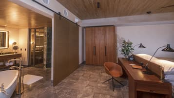A modern bathroom with a bathtub, shower, and wooden wardrobe.