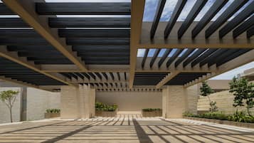 A spacious outdoor area with a modern architectural design, featuring a series of steps leading to a covered area with a view of the sky.