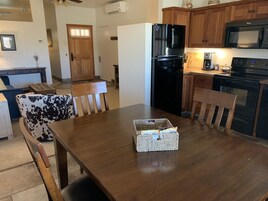 Un comedor con una mesa de madera, sillas y una cesta de objetos.