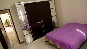 Una camera da letto con un letto, un armadio e uno specchio.