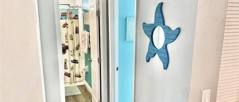 A hallway with a blue wall and a decorative star-shaped mirror.