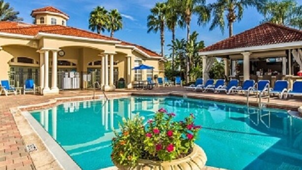 A swimming pool with lounge chairs and palm trees. - 4 BR Pool Home/Close to Disney/Universal/Pool/Spa/BBQ/Wifi/Guard Gated Resort (Kissimmee)