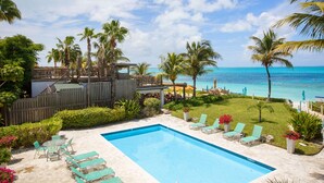 A pool area with lounge chairs and a wooden deck overlooking the ocean. - Relax in your very own private paradise (Providenciales)