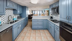 A kitchen with blue cabinets, a tiled backsplash, and a central island.